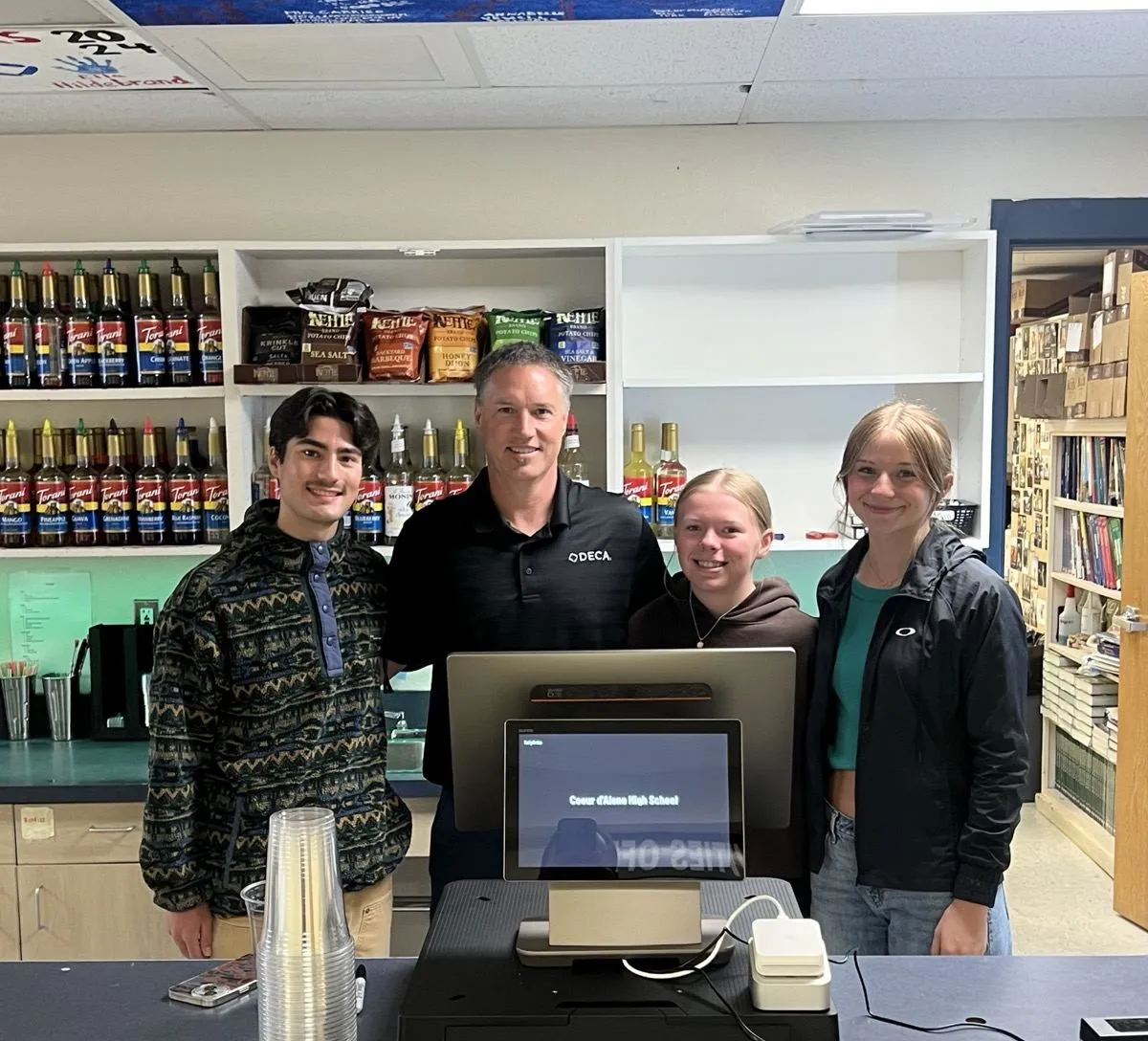 Tony Carrico and the CHS DECA store crew at the Coeur d'Alene High School counter, with the RallyOrder register between them